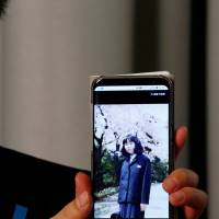 Takuya Yokota displays a picture of his sister Megumi Yokota, who was abducted by North Korean agents decades ago as a schoolgirl, on his smartphone during an interview in Tokyo on Oct. 26. | REUTERS
