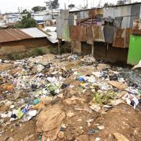 Trash fills a clearing between shacks in Nairobi\'s Kibera slum in in July. Waste management is becoming an urgent issue across Africa. | BLOOMBERG