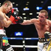 Sergey Lipinets lands a punch on Akihiro Kondo during their IBF super lightweight title fight at Barclays Center in New York on Saturday. | KYODO