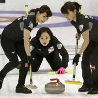 LS Kitami\'s Chinami Yoshida (center) calls the signal to sweepers Yurika Yoshida (left) and Mari Motohashi during the Pacific-Asian Curling Championships final against South Korea on Thursday in Erina, Australia. | KYODO