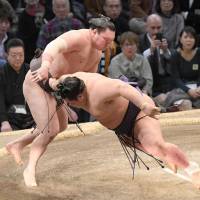 Yokozuna Hakuho outmuscles komusubi Onosho on Saturday at the Fukuoka Grand Sumo Tournament. Hakuho improved to 7-0 with the win. | KYODO