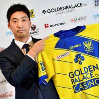 Sint-Truiden board member Yusuke Muranaka holds up a uniform after a news conference on Wednesday in Limburg, Belgium. | AFP-JIJI