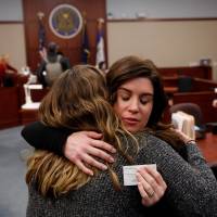 Larissa Boyce (right) gets a hug from Alexis Alvarado, both victims of Larry Nassar, during a hearing in Ingham County Circuit Court on Wednesday in Lansing, Michigan. Former USA Gymnastics team doctor Lawrence (Larry) Nassar, accused of molesting dozens of female athletes over several decades, on Wednesday pleaded guilty to multiple counts of criminal sexual conduct. | AFP-JIJI