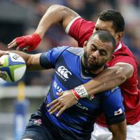 Japan captain Michael Leitch is tackled by Tonga\'s Steve Mafi during Japan\'s 39-6 win on Saturday in Toulouse, France. | AP