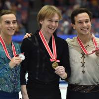 Winner Sergei Voronov of Russia (center), second-place finisher Adam Rippon of the United States (left) and third-place finisher Alexei Bychenko of Israel are seen during the NHK Trophy men\'s awards ceremony on Saturday night. | AFP-JIJI
