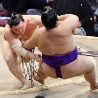 Yokozuna Hakuho overpowers top-ranked maegashira Takakeisho at the Kyushu Grand Sumo Tournament on Tuesday in Fukuoka. | KYODO
