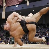 Yokozuna Hakuho defeats Shohozan on Friday at the Fukuoka Grand Sumo Tournament, improving to 13-0 against the maegashira. | KYODO