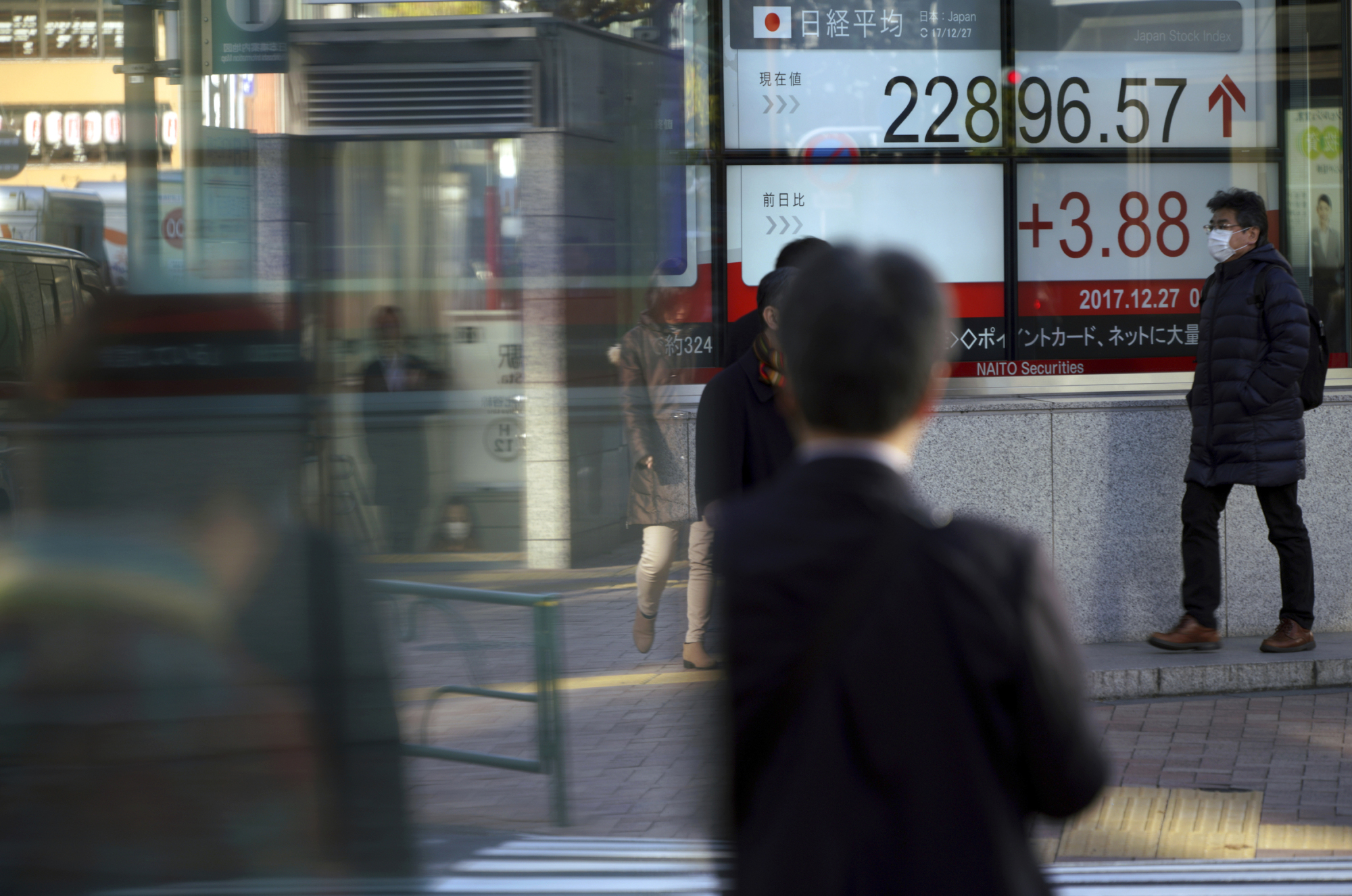 A man walks past an electronic stock board showing the Nikkei 225 index at a securities firm in Tokyo on Wednesday. | AP