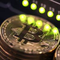 Bitcoin surpassed &#36;12,000 for the first time Wednesday amid speculation that the widespread use of futures will help digital currencies gain mainstream acceptance. | BLOOMBERG