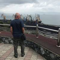 A man looks out over piles of coal in the far eastern port of Nakhodka, Russia, Sept. 5. | REUTERS