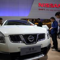 Visitors are seen looking at a Nissan Motor Co. sport-utility vehicle at a trade show in Wuhan, China, in October 2013. | BLOOMBERG