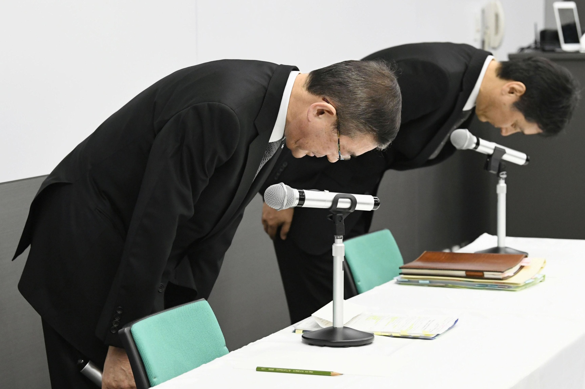 Subaru Corp. President Yasuyuki Yoshinaga (left) apologizes at the start of a news conference in Tokyo on Tuesday. | KYODO