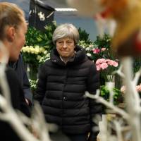 British Prime Minister Theresa May speaks to a shop worker during a visit to VFB The Florist on Small Business Saturday, in Twyford, southeast England, on Saturday. | REUTERS