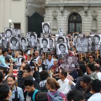 Peruvians holding pictures of victims of the guerrilla conflict in the 1980s and 1990s march in Lima on Thursday against President Pedro Pablo Kuczynski\'s pardon of former President Alberto Fujimori. | REUTERS