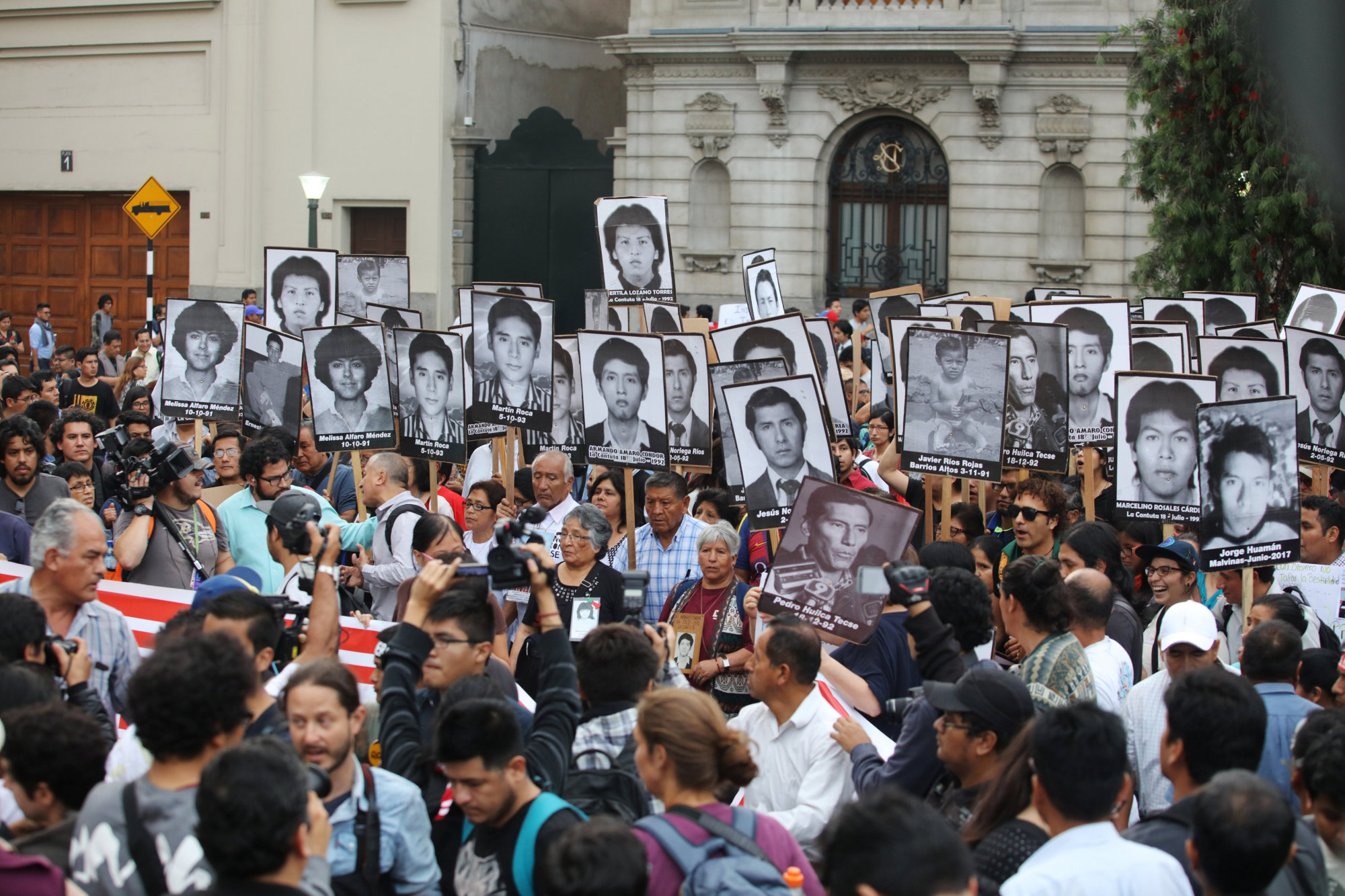 Peruvians holding pictures of victims of the guerrilla conflict in the 1980s and 1990s march in Lima on Thursday against President Pedro Pablo Kuczynski's pardon of former President Alberto Fujimori. | REUTERS