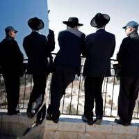 Ultra-Orthodox Jews look at the city of Jerusalem from the Mount of Olives on Friday. The Dome of the Rock mosque is seen on the right. | AFP-JIJI