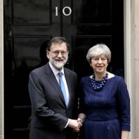 British Prime Minister Theresa May greets Spanish leader Mariano Rajoy before their meeting at No. 10 Downing St. in London on Tuesday. | AP