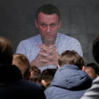 Russian opposition leader Alexei Navalny is seen on a screen in Moscow on Sunday as his supporters gather to uphold his bid for candidate in March\'s presidential election. | REUTERS