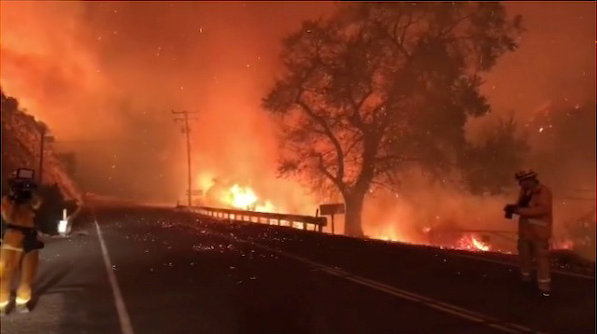 A man takes pictures of wildfires from a highway in Ojai, California, Thuesday in this picture obtained from social media. | INSTAGRAM @EPN106 / VIA REUTERS