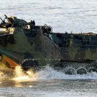 A U.S.-made AAV-7 amphibious vehicle rumbles onto the beach at the U.S. Marines\' Camp Pendleton in California in February 2015. A delay in delivery to the Ground Self-Defense Force means Japan\'s new amphibious unit will launch in March with only seven AAV-7s. | KYODO