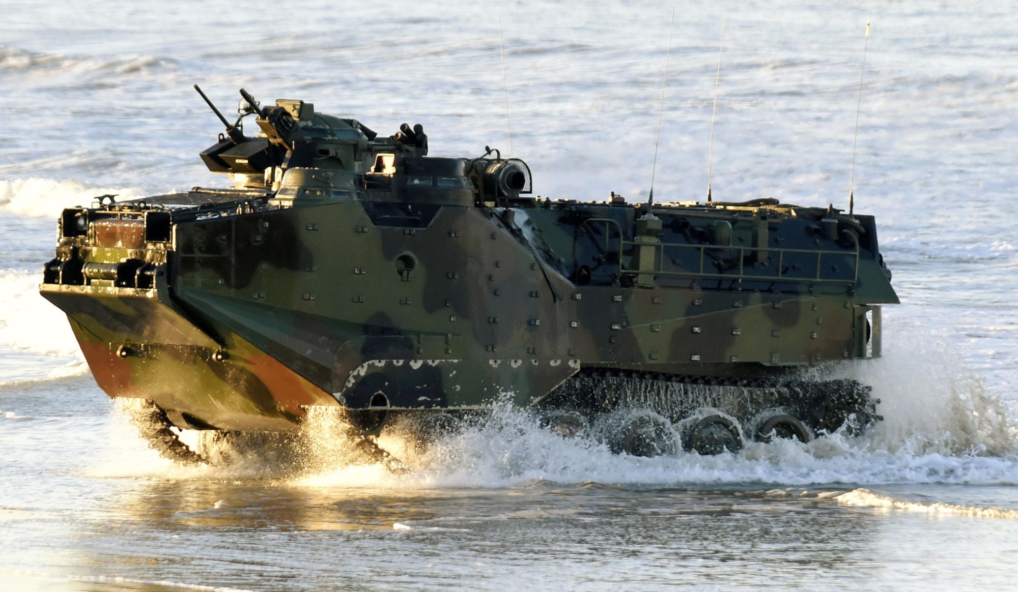 A U.S.-made AAV-7 amphibious vehicle rumbles onto the beach at the U.S. Marines' Camp Pendleton in California in February 2015. A delay in delivery to the Ground Self-Defense Force means Japan's new amphibious unit will launch in March with only seven AAV-7s. | KYODO