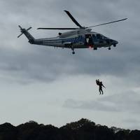 Japan Coast Guard members perform a helicopter evacuation drill at a public festival in late November. | AARON BERMAN