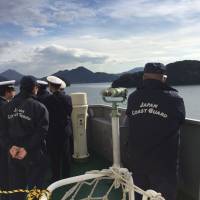 Crew members stand watch on deck of the Daisen. | AARON BERMAN