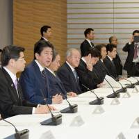 Prime Minister Shinzo Abe (second from left) speaks at a Cabinet meeting Friday at the Prime Minister\'s Office to discuss tourism promotion. | KYODO