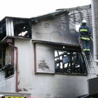 A gutted apartment is inspected in Toyonaka, Osaka Prefecture, on Saturday after a blaze killed five people there Friday night. | KYODO