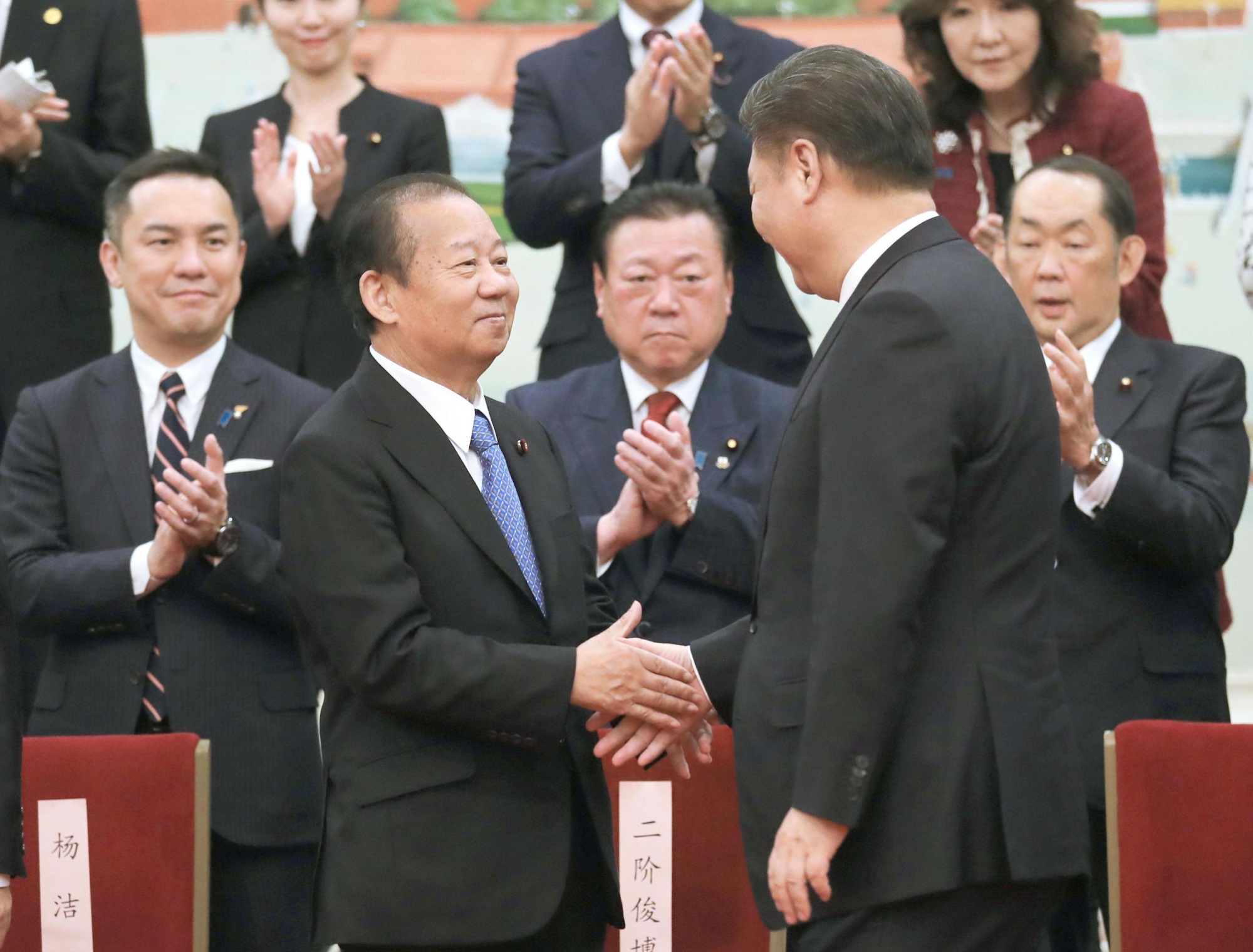 Japanese ruling party heavyweight Toshihiro Nikai (left) shakes hands with Chinese President Xi Jinping during their meeting Thursday in Beijing. | KYODO