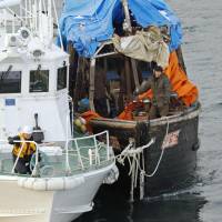 A Japan Coast Guard patrol boat tows a North Korean fishing boat toward Hakodate port in Hokkaido earlier this month. | KYODO