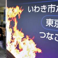 A signboard welcoming the torch relay for the 2020 Tokyo Olympics is seen in front of the Iwaki Municipal Government building in Fukushima Prefecture in August. | KYODO