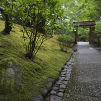 A moss-covered statue lies next to a path in the Portland Japanese Garden. | CHRISTINA SJOGREN