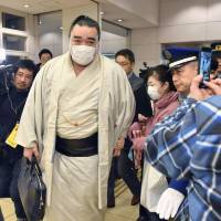Sumo-size trouble: Harumafuji makes his way through a gaggle of reporters and photographers after a news conference in November where he announced his retirement from sumo wrestling. | KYODO