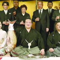 Kisenosato holds up a red sea bream during a formal ceremony in which he was officially promoted to the rank of yokozuna. | KYODO