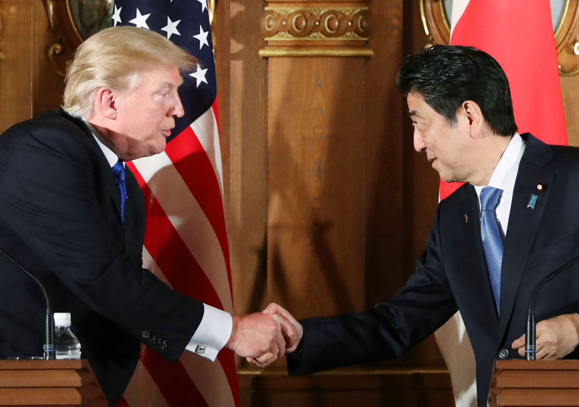 Different strokes: U.S. President Donald Trump and Prime Minister Shinzo Abe shake hands after a press conference in Tokyo on Nov. 6. During his visit Trump said Japan should be buying more military hardware from the U.S., but the nation has its own plans. | POOL / KYODO