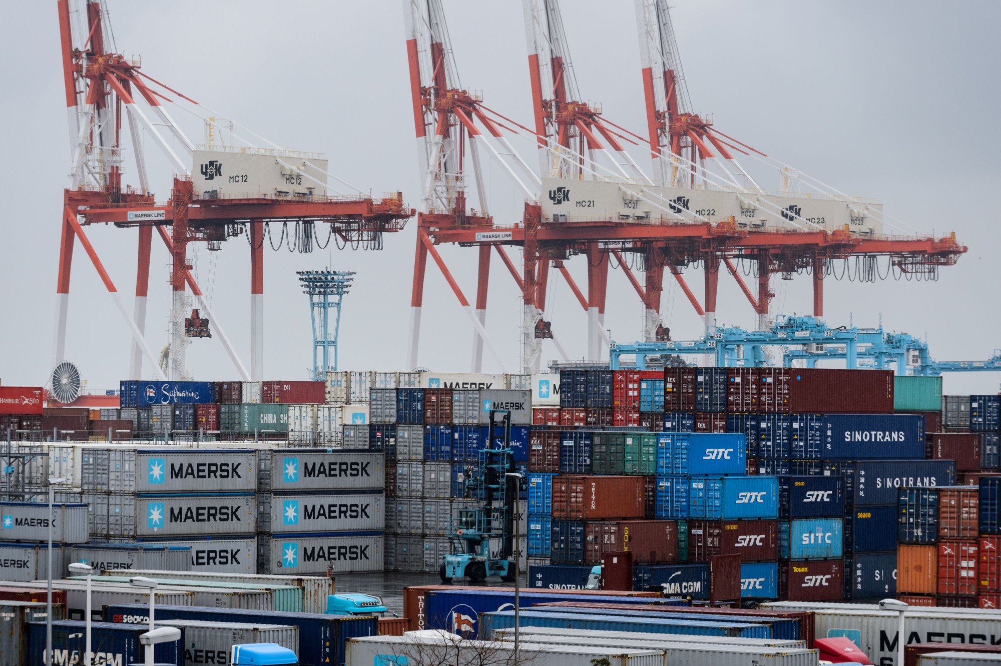 Containers sit stacked next to gantry cranes at a Yokohama shipping terminal in March. Japan is the world's fourth-largest export economy, but only 25 percent of its small and medium-size manufacturers sell their products abroad. | BLOOMBERG