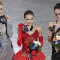 Russian gold medalist Alina Zagitova (center) is joined by compatriot and runner-up Maria Sotskova (left) and Canadian third-place finisher Kaetlyn Osmond for a group photo after receiving their awards on Saturday at the Grand Prix Final. | AP
