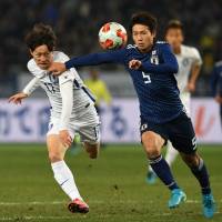 Japan\'s Shintaro Kurumaya (left) and South Korea\'s Lee Jae-sung compete for the ball on Saturday. | AFP-JIJI