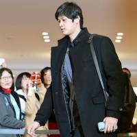 Shohei Ohtani walks through Narita airport on Tuesday. | KYODO