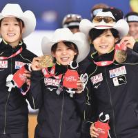 apan’s Ayaka Kikuchi (left), Nana Takagi (center) and Miho Takagi show off their medals after winning the women’s speedskating team pursuit in a new world-record time of 2 minutes, 53.88 seconds at a World Cup event in Calgary, Alberta, on Saturday.  | KYODO