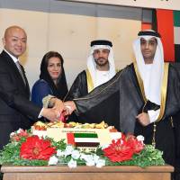 United Arab Emirates Ambassador Khaled Alameri (second from right) cuts a cake during a ceremony to celebrate the country\'s national day at Palace Hotel Tokyo on Nov. 27. Alameri is photographed with (from left) Manabu Horii, parliamentary vice-minister of foreign affairs, First Secretary Fatima Jumah Mohammed Aldhmani and Second Secretary Suood Ebrahim Leamash. | YOSHIAKI MIURA