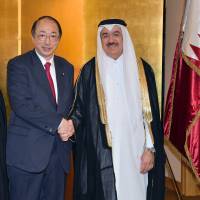 Qatar Ambassador Yousef Mohamed Bilal (right) welcomes Environment Minister Masaharu Nakagawa during a reception to celebrate the Qatar\'s national day at Imperial Hotel on Dec. 13. | YOSHIAKI MIURA