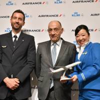 Air France-KLM Chairman and Chief Exective Officer Jean-Marc Janaillac (center) poses with the airline\'s crew members during a news conference at Tokyo Midtown on Dec. 14. | YOSHIAKI MIURA
