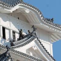 Ground Self-Defense Force members sweep soot off Himeji Castle in Himeji, Hyogo Prefecture, on Wednesday ahead of the new year. The structure, a UNESCO World Heritage site, known as White Heron Castle because of its brilliant white exterior, is one of the most visited castles in the country. | KYODO