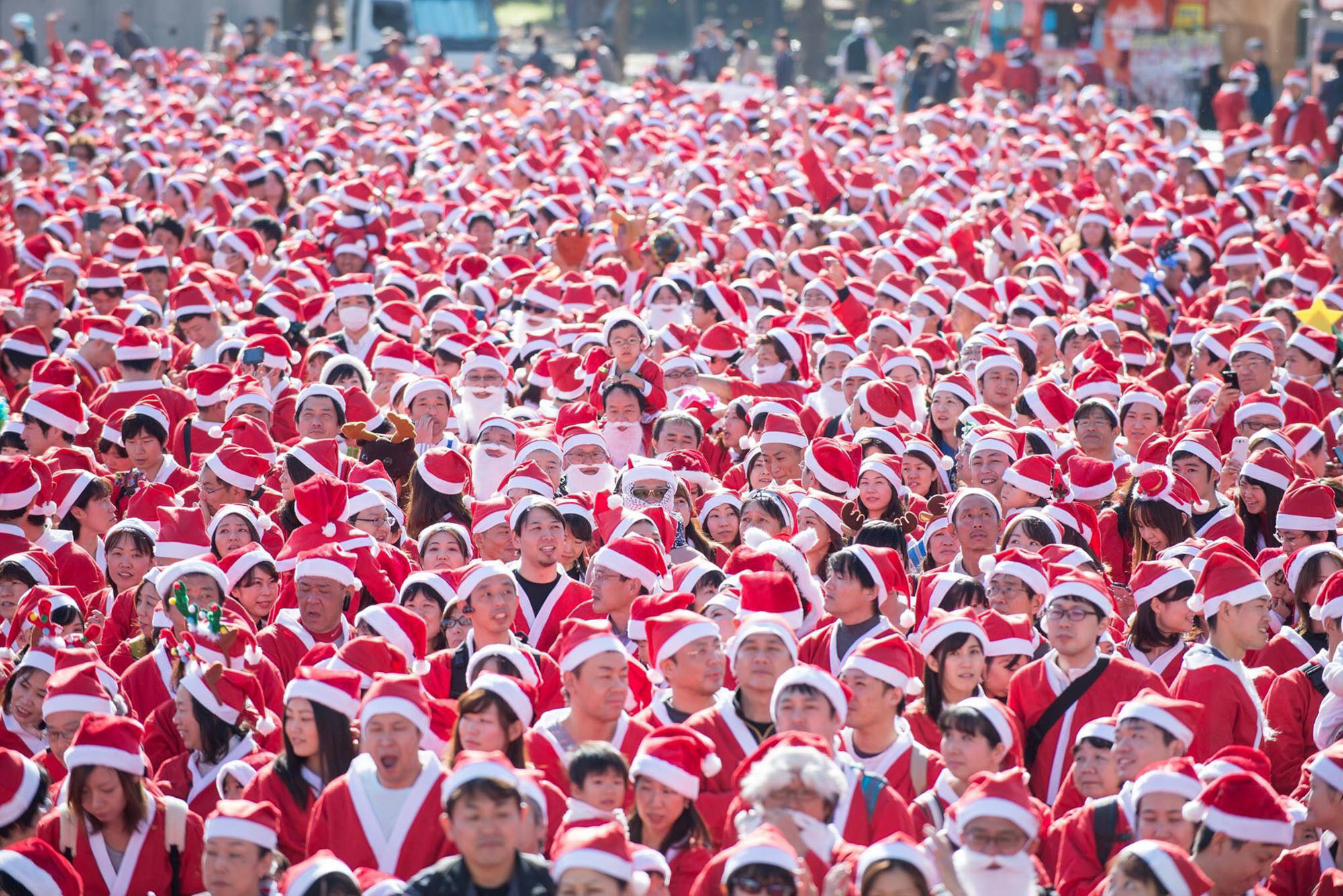 Some 5,500 people dressed as Santa Claus participate in a walking event Sunday at Osaka Castle Park in the city of Osaka. A portion of the fees paid to join the event will be used to buy Christmas gifts for children in hospitals, the organizer said. | OSAKA GREAT SANTA RUN