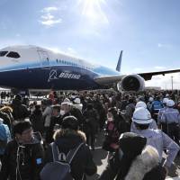 Hundreds of spectators Sunday at Chubu Centrair International Airport outside Nagoya watch a prototype Boeing 787 being towed to a commercial complex. Traffic had to be blocked off so the aircraft could cross a public road to reach the complex, where it will eventually go on display. | KYODO