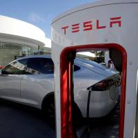 A Tesla Model X vehicle is charged by a supercharger outside a Tesla electric car dealership in Sydney. | REUTERS