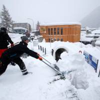 Staff remove snow ahead of the World Economic Forum (WEF) annual meeting in the Swiss Alps resort of Davos Sunday. | REUTERS