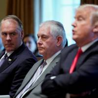 U.S. Interior Secretary Ryan Zinke (left) looks on with Secretary of State Rex Tillerson as U.S. President Donald Trump holds a Cabinet meeting at the White House in Washington Wednesday. | REUTERS
